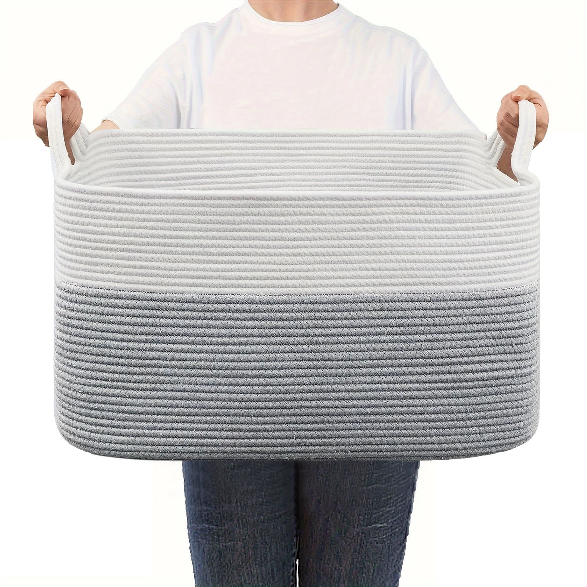 A person holds a gray woven cotton rope storage basket for organization.
