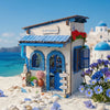 A miniature Greek-style house for a beach corner DIY book nook kit with blue and white accents