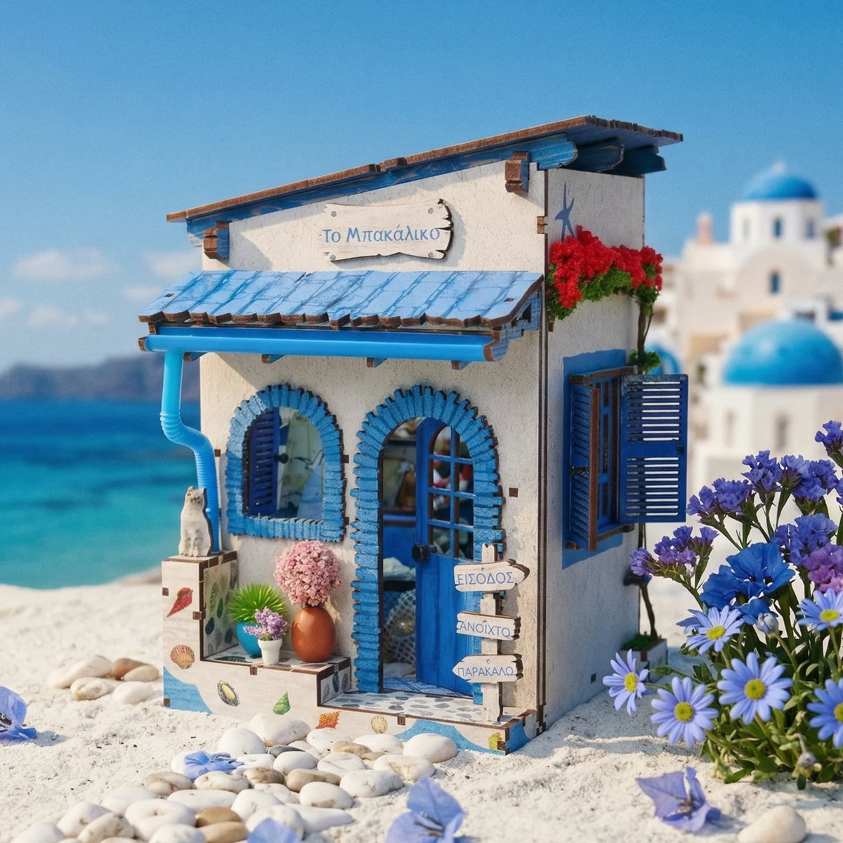 A miniature Greek-style house for a beach corner DIY book nook kit with blue and white accents