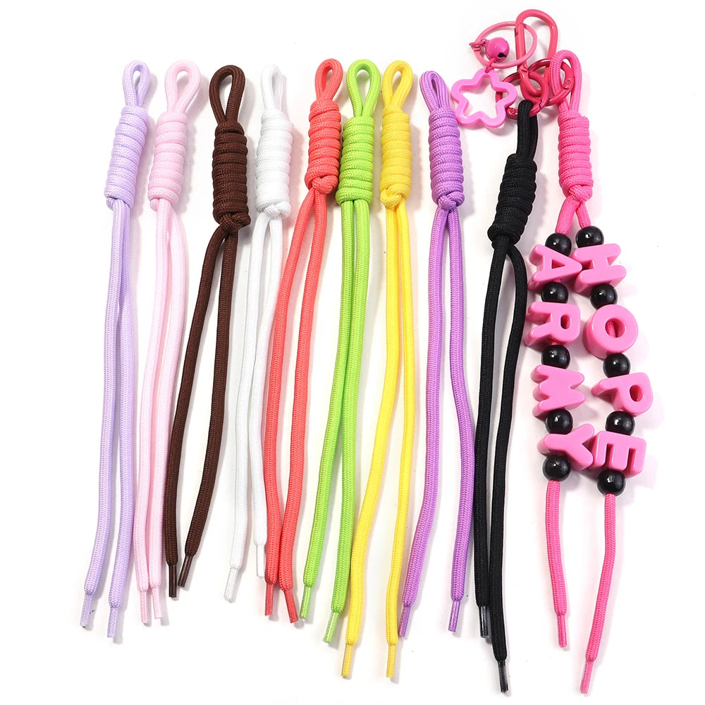 A collection of colorful braided nylon lanyards and keychains in various shades including pink, purple, green, yellow, and bl