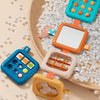 A wooden board features colorful sensory folding activity cubes for toddlers, demonstrating fine motor skills.