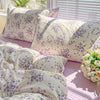 A set of lavender floral duvet covers and pillowcases with white background and purple flowers on a bed.