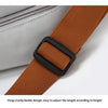 A close-up of a brown strap with a black buckle, used to adjust the length on a gray travel duffle bag.