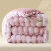 A thick, pink faux fur comforter or quilt folded and displayed on a light surface.