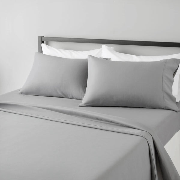 A gray bed sheet set with white pillows and a matching gray duvet on a bed.