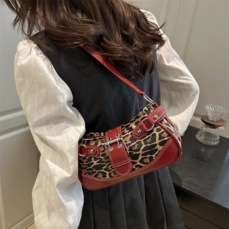 A close-up of a red leopard print PU leather shoulder bag worn by a person, set against a dark background.