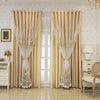 Double layer embroidered beige blackout curtain panels hanging in a bright room.