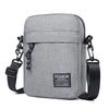 A gray mini crossbody phone bag with a black adjustable strap is shown against a white background.