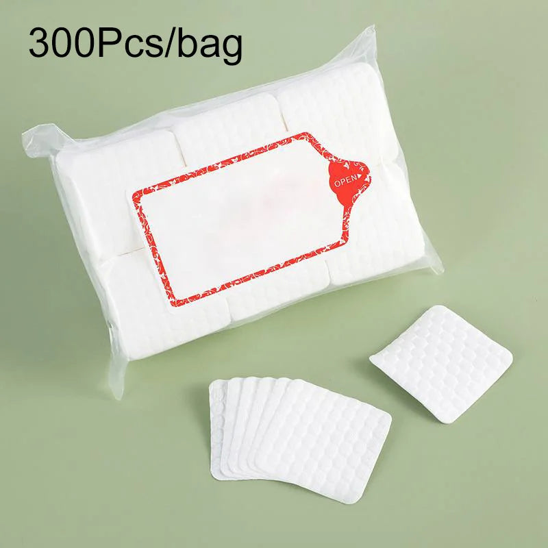 A clear plastic bag containing 300 pieces of white lint-free cotton rounds for nail care.