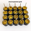 A set of ten electroplated gold alloy car wheels and tires displayed in a row.