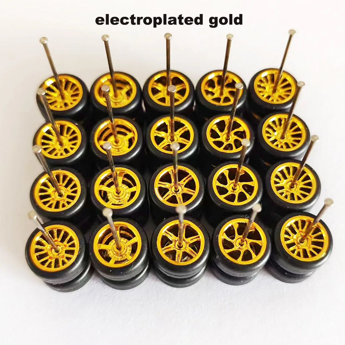 A set of ten electroplated gold alloy car wheels and tires displayed in a row.