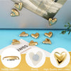 A set of twelve gold heart-shaped refrigerator magnets displayed on a blue surface.