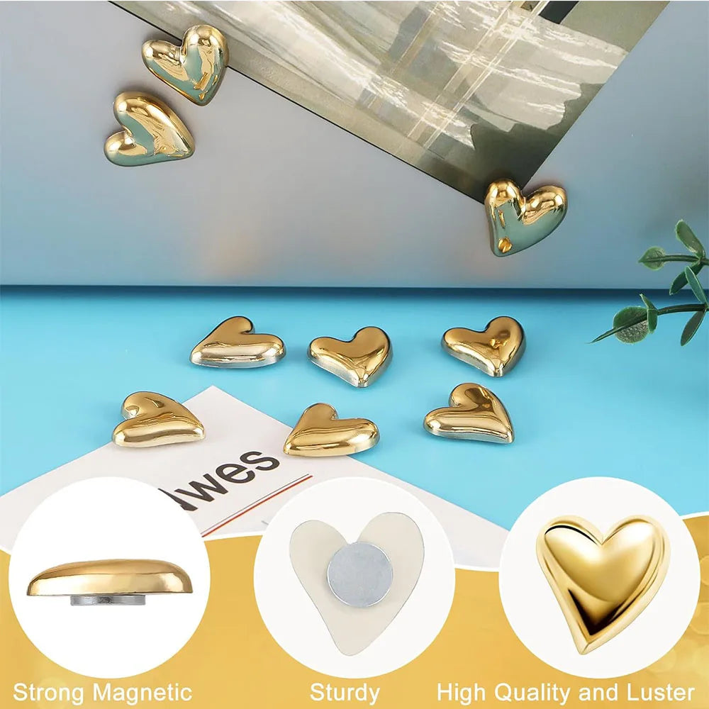 A set of twelve gold heart-shaped refrigerator magnets displayed on a blue surface.