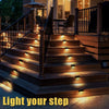 Outdoor wooden stairs illuminated by warm LED lights for safety and visibility.