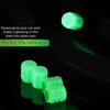 A set of ten glowing green tire valve caps illuminating in the dark.