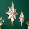 A gold-framed octagonal star resin wall mirror mounted on a dark green wall.