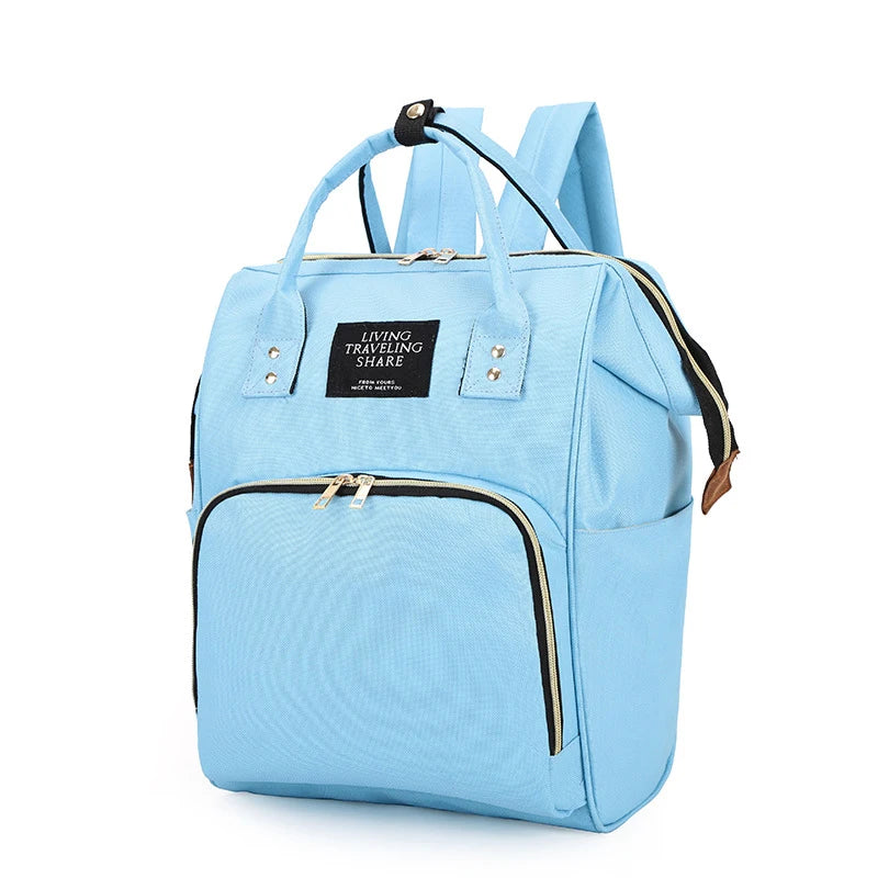Light blue insulated canvas mummy diaper bag with a hanging hook and zippered pockets