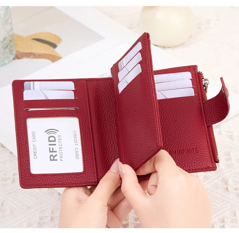 A close-up of a maroon RFID-blocking bi-fold wallet showing credit cards inside.
