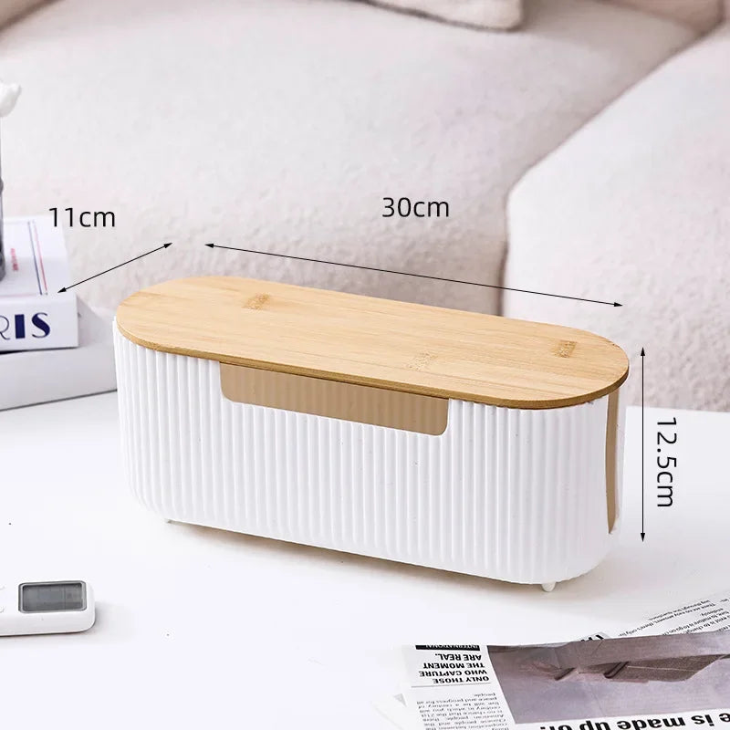 A white and wood cable management box organizer for power strips shown on a desk surface.