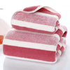 A set of pink and white striped microfiber bath towels folded neatly.