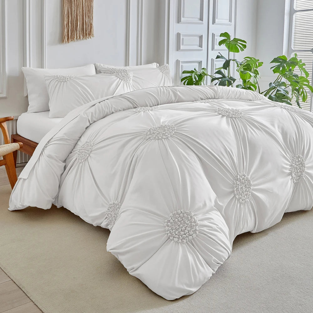 White three-dimensional pleated floral duvet cover set displayed on a bed with white pillows and greenery in the background