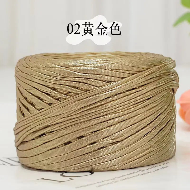 A spool of metallic gold flat ribbon yarn for crochet and knitting