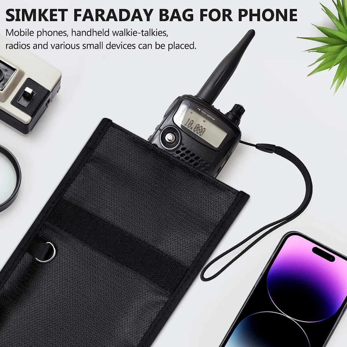 Black Faraday bag protecting a mobile phone and small devices next to a walkie-talkie radio.