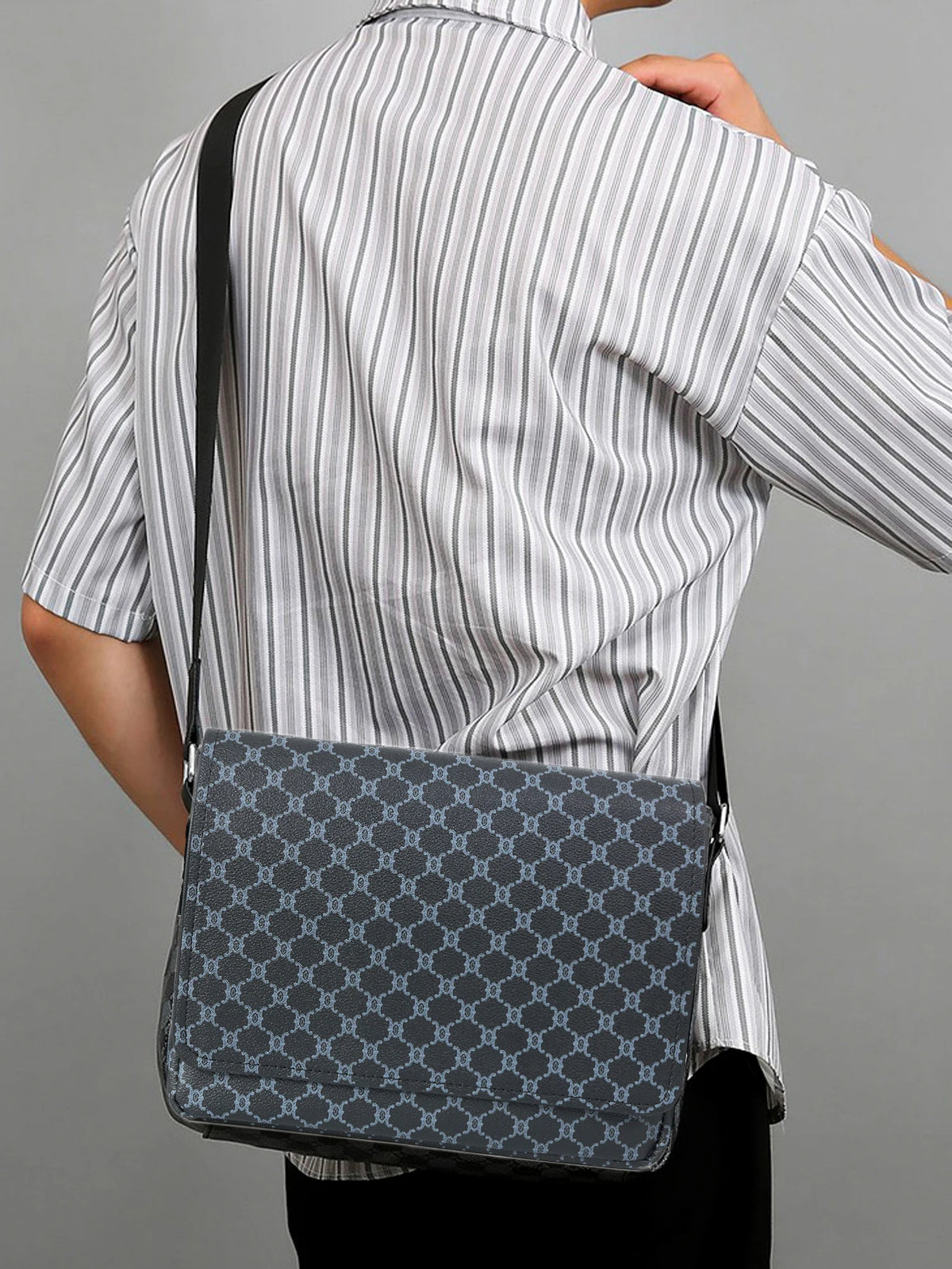 A woman wearing a striped shirt holds a gray patterned crossbody bag on her shoulder.