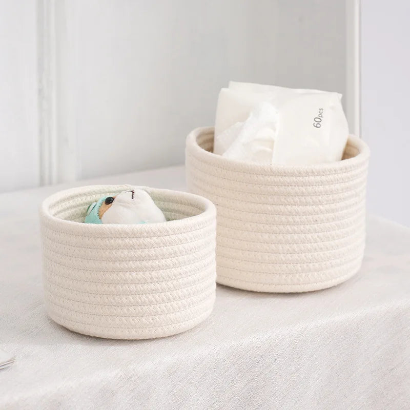 A natural beige handwoven cotton rope storage basket filled with white tissues and placed on a light surface.