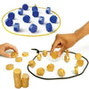 A hand places magnetic strategy game pieces, colored blue and gold, onto a circular mat.
