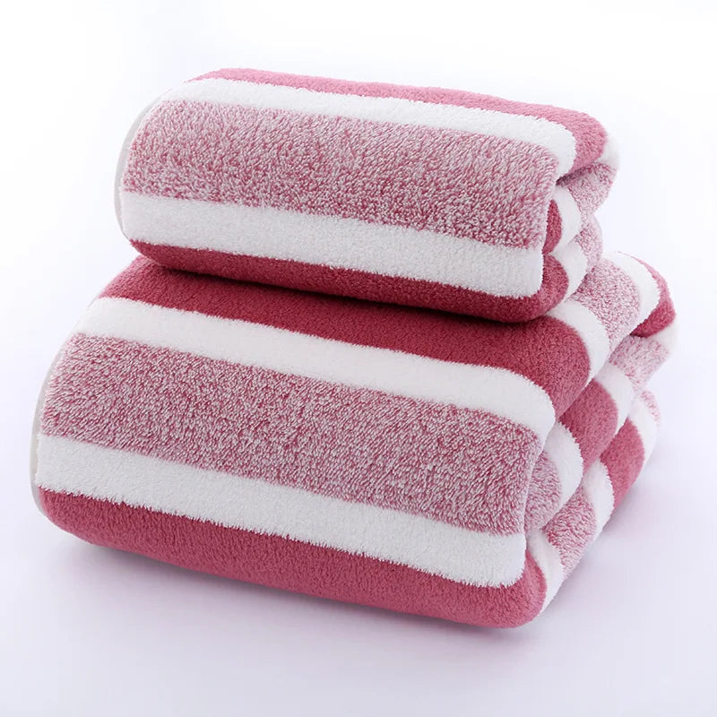 A stack of pink and white striped microfiber towels for bath and face use.