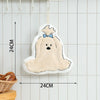 A fluffy, light beige cartoon dog hanging towel with a blue bow, displayed on a kitchen rack.