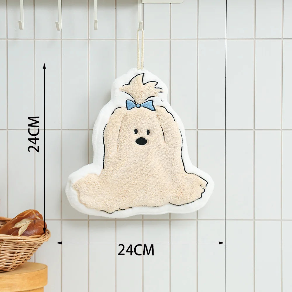 A fluffy, light beige cartoon dog hanging towel with a blue bow, displayed on a kitchen rack.