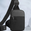 A black compact canvas crossbody sling bag with a strap is shown against a light gray background.
