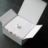 A white box is open, revealing a prewound bobbin with polyester thread inside.