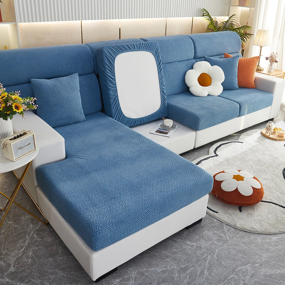 A light blue elegant jacquard sofa slipcover with white cushions and a matching white frame in a modern living room.