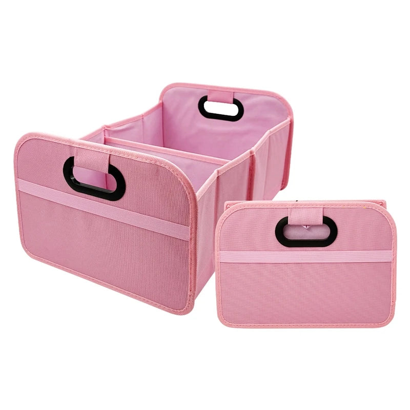 Pink foldable car trunk organizer with carry handles for securing items in the trunk.
