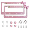 Pink rhinestone license plate frame with a bow accent and mounting hardware.