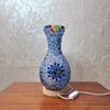 Handcrafted Turkish mosaic vase lamp with blue and multicolored glass on a wooden table.