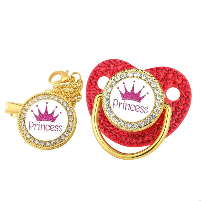 A set of crystal rhinestone pacifier chain clips with silicone nipples and gold accents.