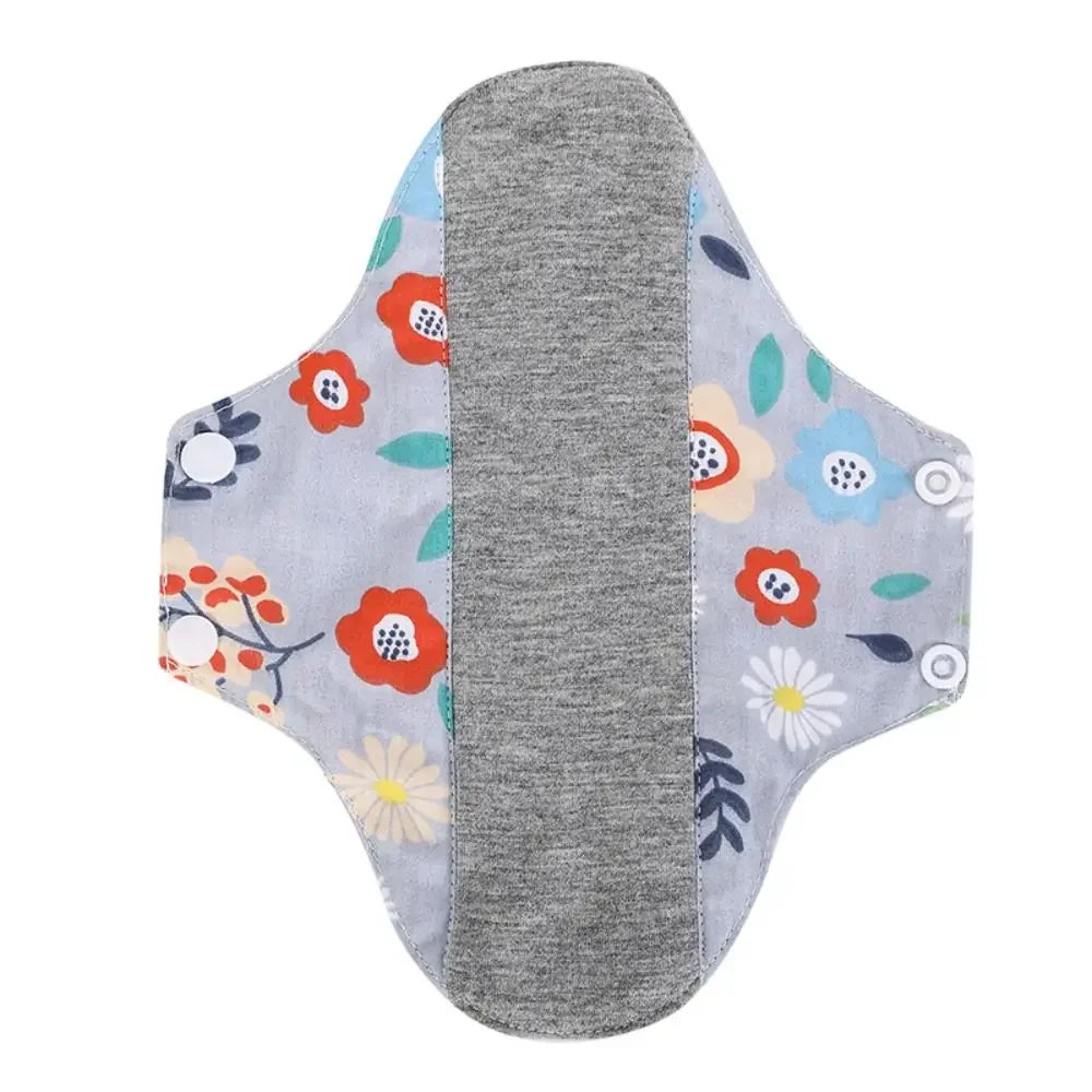 Reusable cotton menstrual pads with a gray absorbent core and floral patterned outer layer.