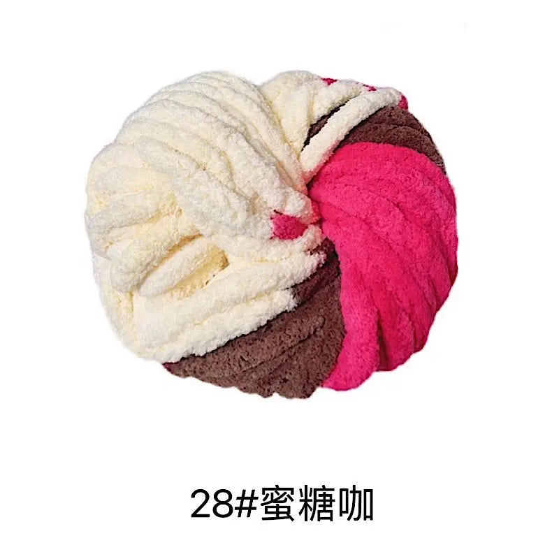 A ball of chunky acrylic yarn in white, brown, and pink colors for knitting and crochet.