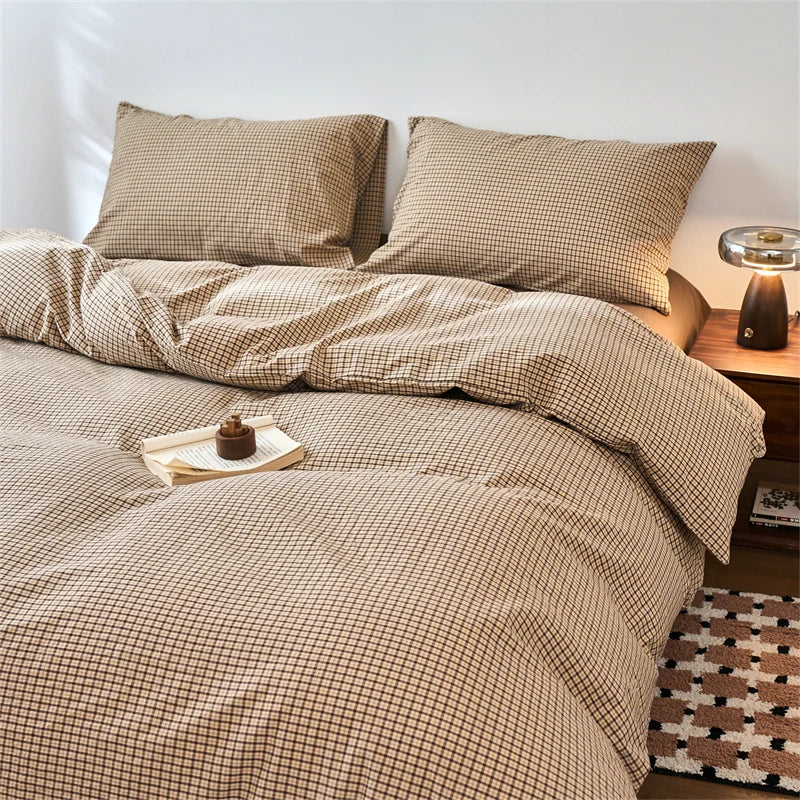 A beige plaid duvet cover with a subtle grid pattern is displayed on a bed.