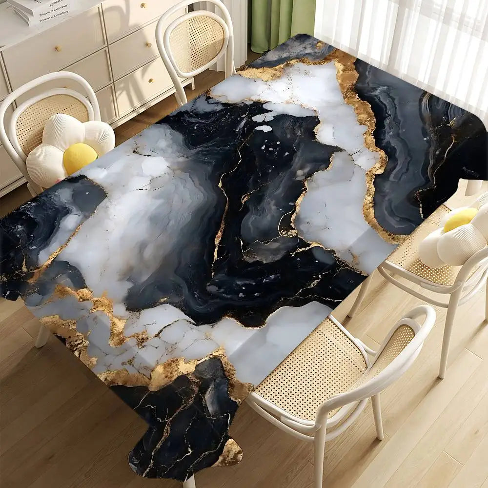 A black and white marble tablecloth with gold veining is displayed on a wooden table in a bright room.