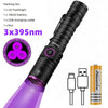 A black UV flashlight with a purple beam, packaged with a battery and USB cable.