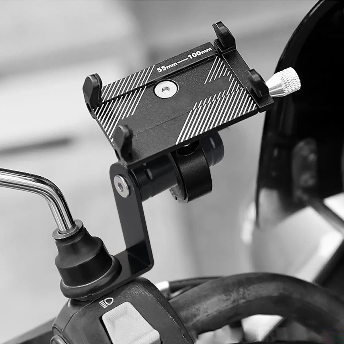 A black phone mount is attached to a bicycle handlebar, designed for mounting a phone.