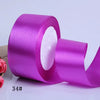 A roll of vibrant purple satin ribbon used for gift wrapping and crafts.