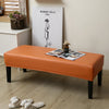 An orange waterproof PU stretch bench cover placed on a wooden floor in a room with a framed artwork.
