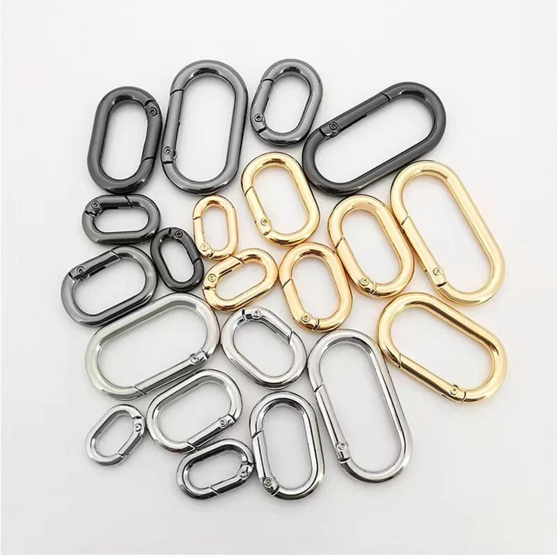 Eine Sammlung ovaler federförmiger O-Ring-Schnallen in verschiedenen Finishes wie Silber, Gold und Schwarz.