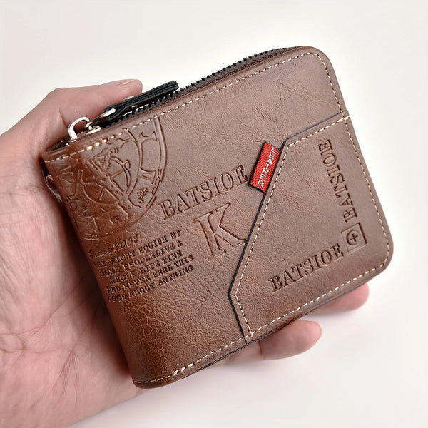 A brown leather compact zip-around wallet with a coin pocket is held in a hand.